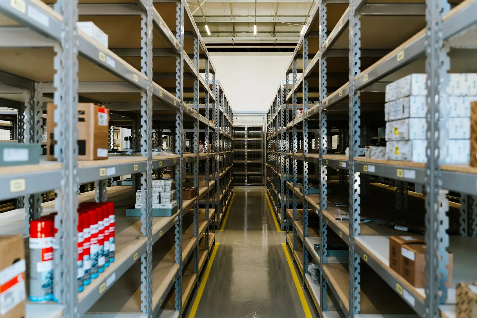 Centro de distribuição organizado, com prateleiras metálicas e mercadoria estocada